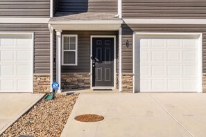 A two-story house with a front door, two garage doors, and a stone accent wall. - ‼️New 3BR Raceday Retreat - Steps from Speedway (Bristol)