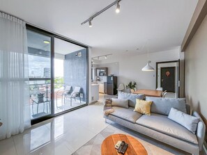 Una sala moderna con sofá, mesa de centro y vistas al balcón.