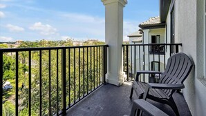 A balcony with a view of a residential area, a white column, and two Adirondack chairs. - 4126 Vista Cay (Orlando)
