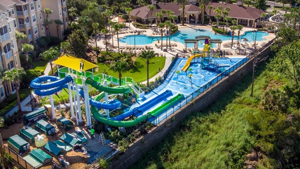 A resort with a large pool, water slides, and a building with balconies. - 2627 Windsor Hills (Kissimmee)