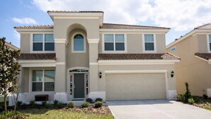 A two-story house with a central entrance, a garage, and a well-maintained lawn. - 2540 Windsor Hills (Kissimmee)
