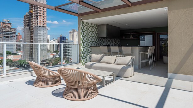 A rooftop terrace with a glass ceiling, a sofa, two wicker chairs, and a bar area. - Cozy Studio in Cambuí (Campinas)