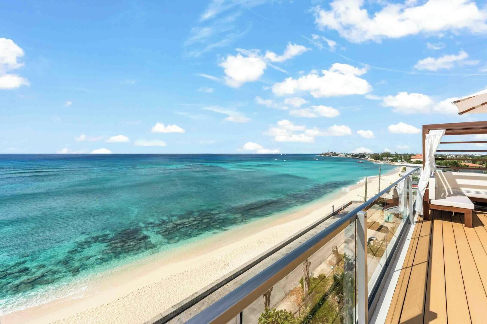 Un balcón con vista a la playa y al océano.
