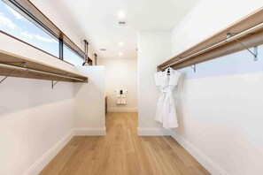 Ein modernes Hotelzimmer mit Holzboden, weißen Wänden und einem großen Fenster.