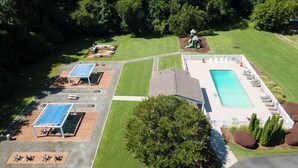An aerial view of a property with a swimming pool, two sun loungers, a small play area, and a covered patio. - Charming 1-bedroom apartment with AC in vibrant Durham (Durham)