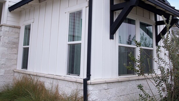 Een wit gebouw met zwarte accenten en een puntgevel.