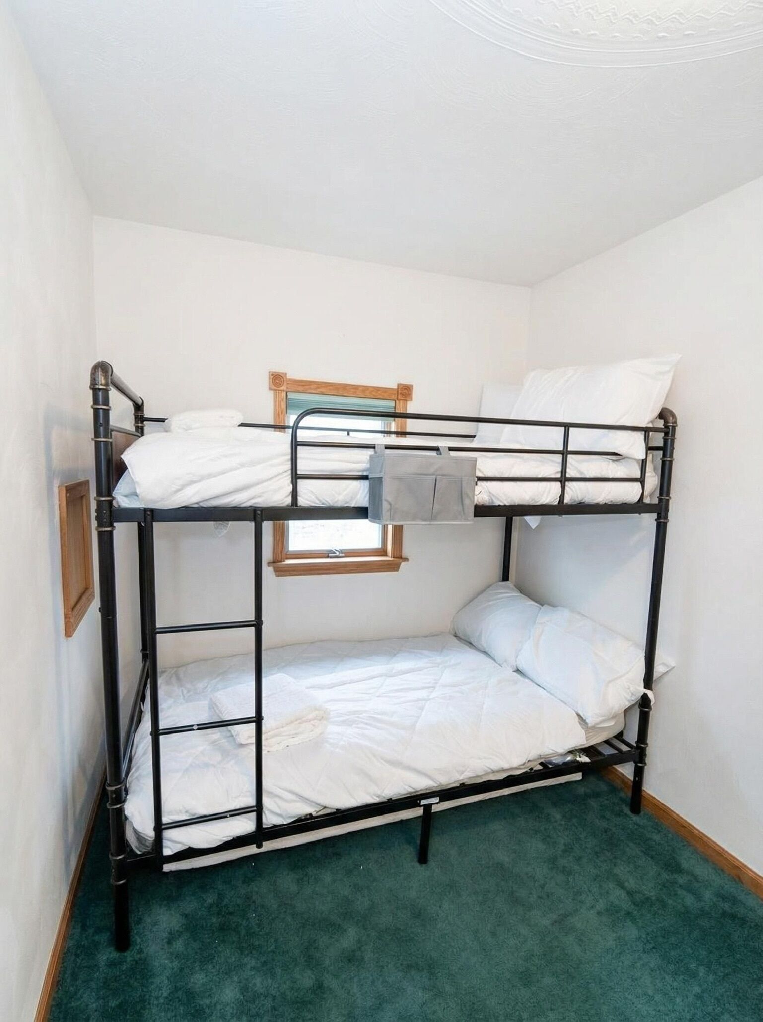Una cama litera con ventana sobre la cama inferior.