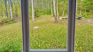 Ein Zimmer mit großen Fenstern und Blick auf ein bewaldetes Gebiet.