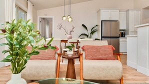 A modern living room with two armchairs, a coffee table, and a dining area. - Modern Japandi Home with Fire-Pit Evenings and Fast Internet (Meridian)