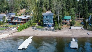 A lakeside property with a dock, a large house with a deck, and a smaller cabin. - Private Dock, Kayaks, SUPs, Lakefront Views (Celista)
