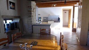 A cozy kitchen with a wooden dining table, chairs, and a coffee maker. - The Récourt Gardens (Récourt)