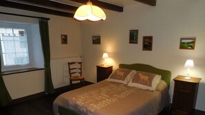 A bedroom with a bed, two bedside lamps, a chair, and a window with curtains. - Gabrielle's House (Giey-sur-Aujon)
