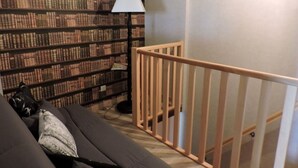 A bedroom with a bed, a wooden railing, a bookshelf, and a lamp. - MAISON ROSALICE - Chaumont-la-Ville (Chaumont-la-Ville)