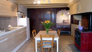 A compact kitchen with a dining table, chairs, a refrigerator, and a stove. - MAISON ROSALICE - Chaumont-la-Ville (Chaumont-la-Ville)