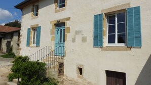 A two-story building with a stone facade, blue shutters, and a small staircase leading to the entrance. - Graine - Dommartin-le-Franc (Dommartin-le-Franc)