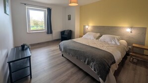 A bedroom with a bed, bedside tables, a desk, a window, and a lamp. - Graine - Dommartin-le-Franc (Dommartin-le-Franc)