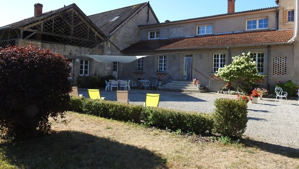 A building with a courtyard, outdoor seating, and a garden. - Gîte de la Forge - ROCHES-BETTAINCOURT (ROCHES-SUR-ROGNON)