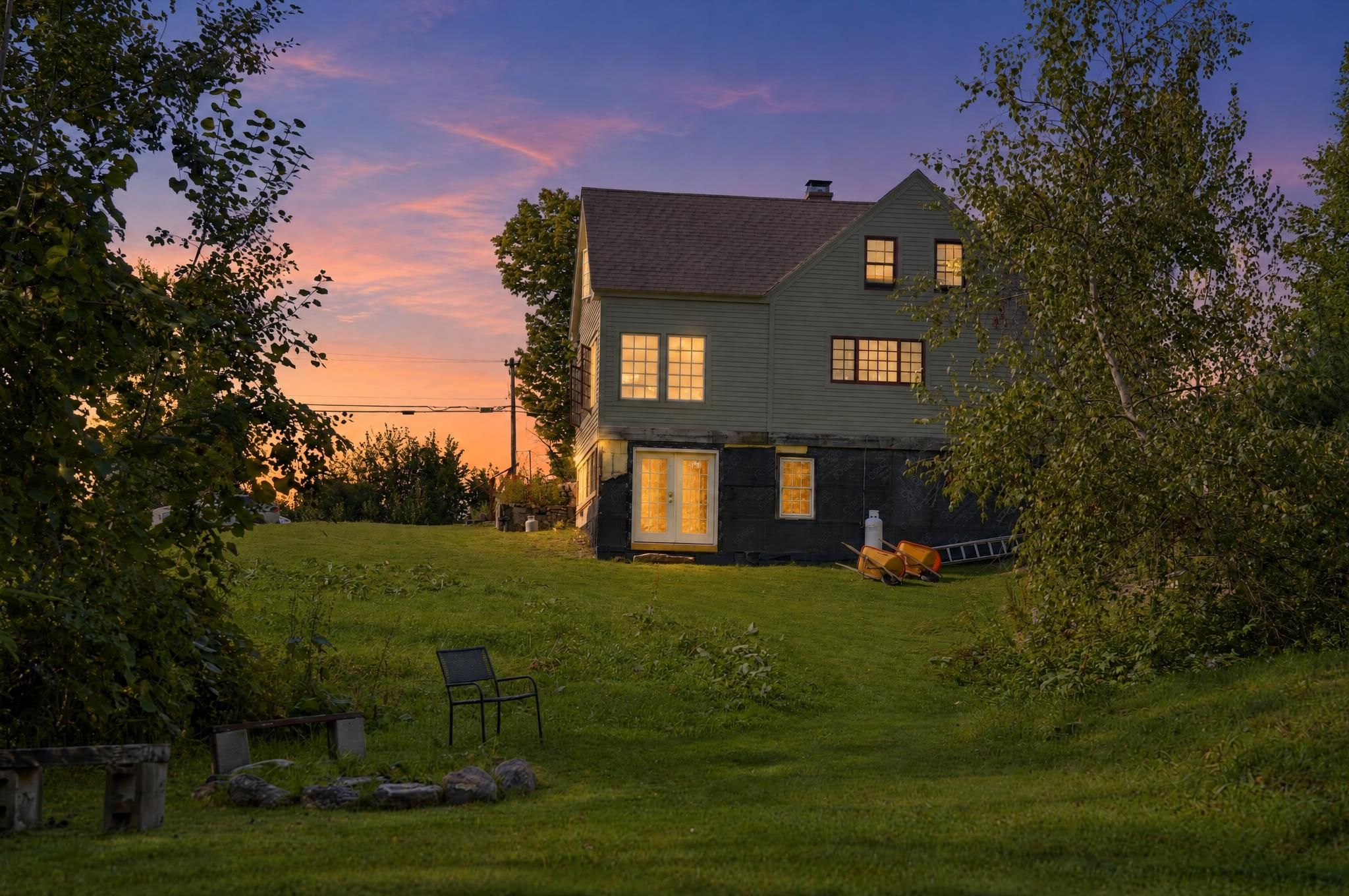 A two-story house with a dark exterior and a well-maintained lawn.