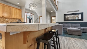 Una cocina moderna con armarios de madera, encimera de granito y una lámpara colgante.