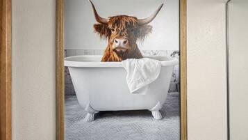 Une photographie encadrée représentant une vache des Highlands dans une baignoire.