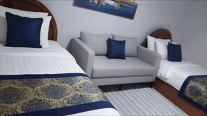 A hotel room with two beds, a sofa, and a patterned rug.