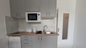 Una cocina compacta equipada con microondas, tostadora y cafetera.