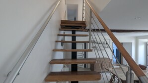 En moderne trappe med trætrapper og metalgel ændere, der fører op til en etage.