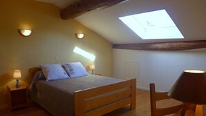 A bedroom with a wooden bed, two bedside lamps, a skylight, and a wooden chair. - The White Stones (Aubepierre-sur-Aube)