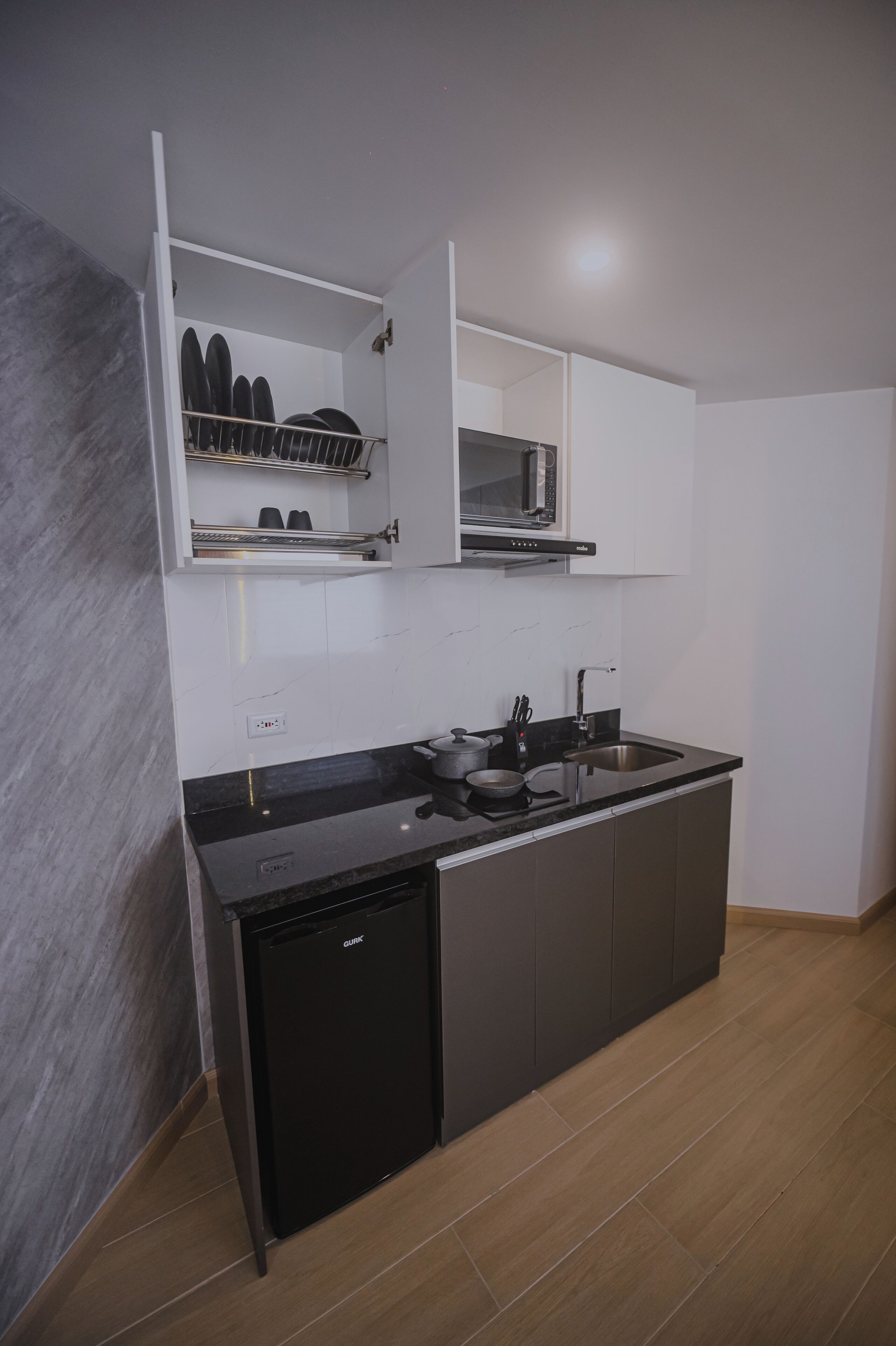 A modern kitchen with a dishwasher, a microwave, and a sink.