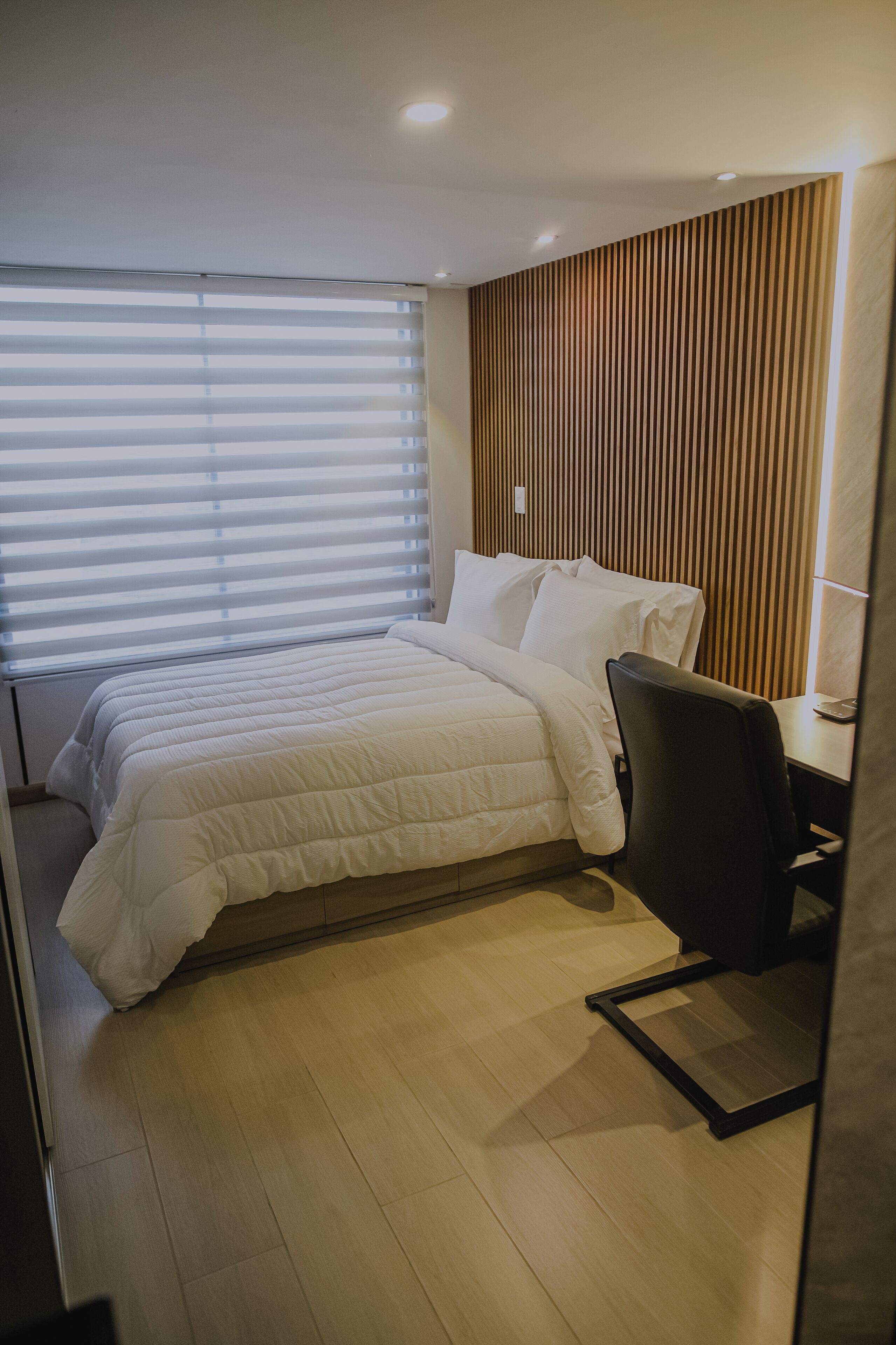 Ein Hotelzimmer mit Bett, Schreibtisch und Stuhl.