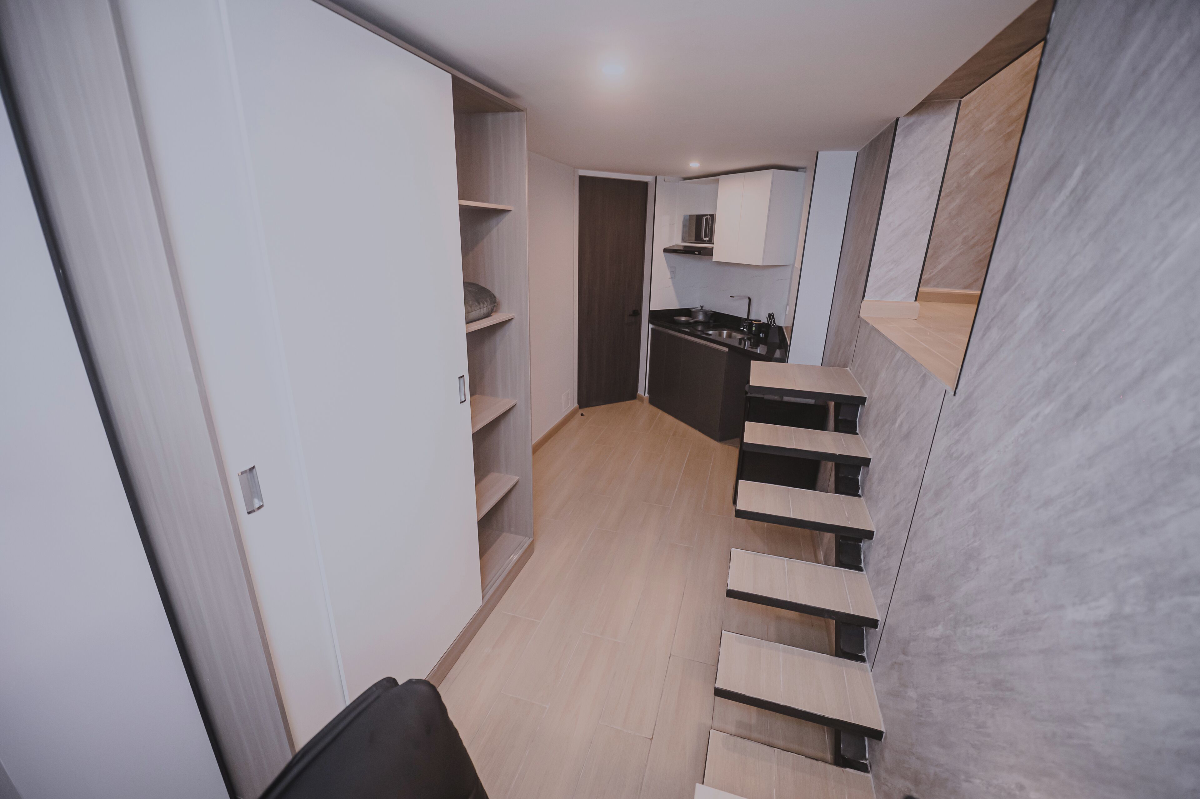 A modern kitchen with a black stove, white cabinets, and a microwave.