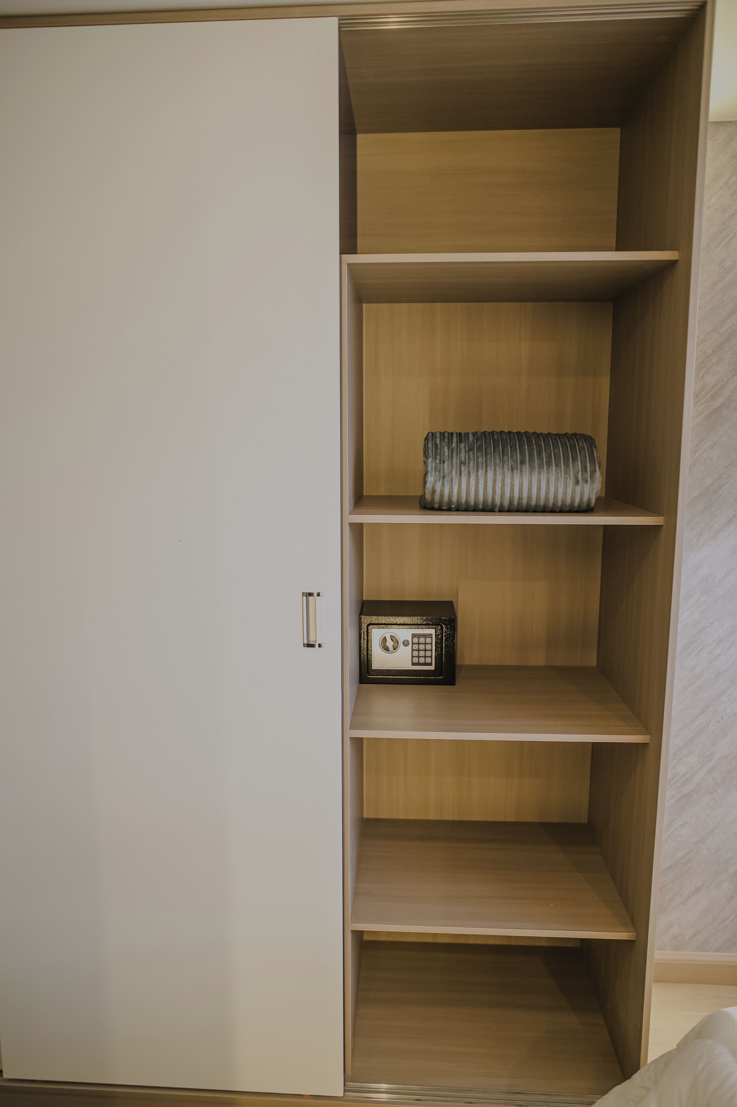 Una habitación con armario, radio y estante con un objeto enrollado.