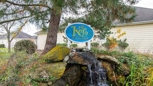 Un panneau indiquant « Keys of Marsh Harbor », avec une petite cascade en premier plan.