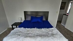A bed with a blue bedspread and a white furry throw blanket. - Shagbark - 7 Beds - 4 Baths (St. Peters)