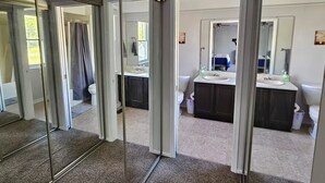 A modern bathroom with a glass shower enclosure, a white sink, and dark cabinetry. - Shagbark - 7 Beds - 4 Baths (St. Peters)