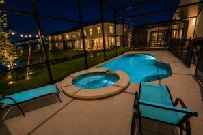 Ein Schwimmbecken mit Whirlpool, umgeben von einer überdachten Terrasse mit Sitzgelegenheiten.