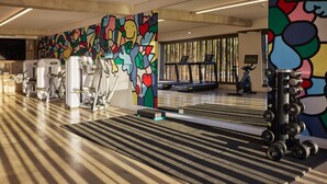 A gym with exercise equipment, a mirrored wall, and a patterned floor. - Thalassa Villas (Agios Nikolaos)