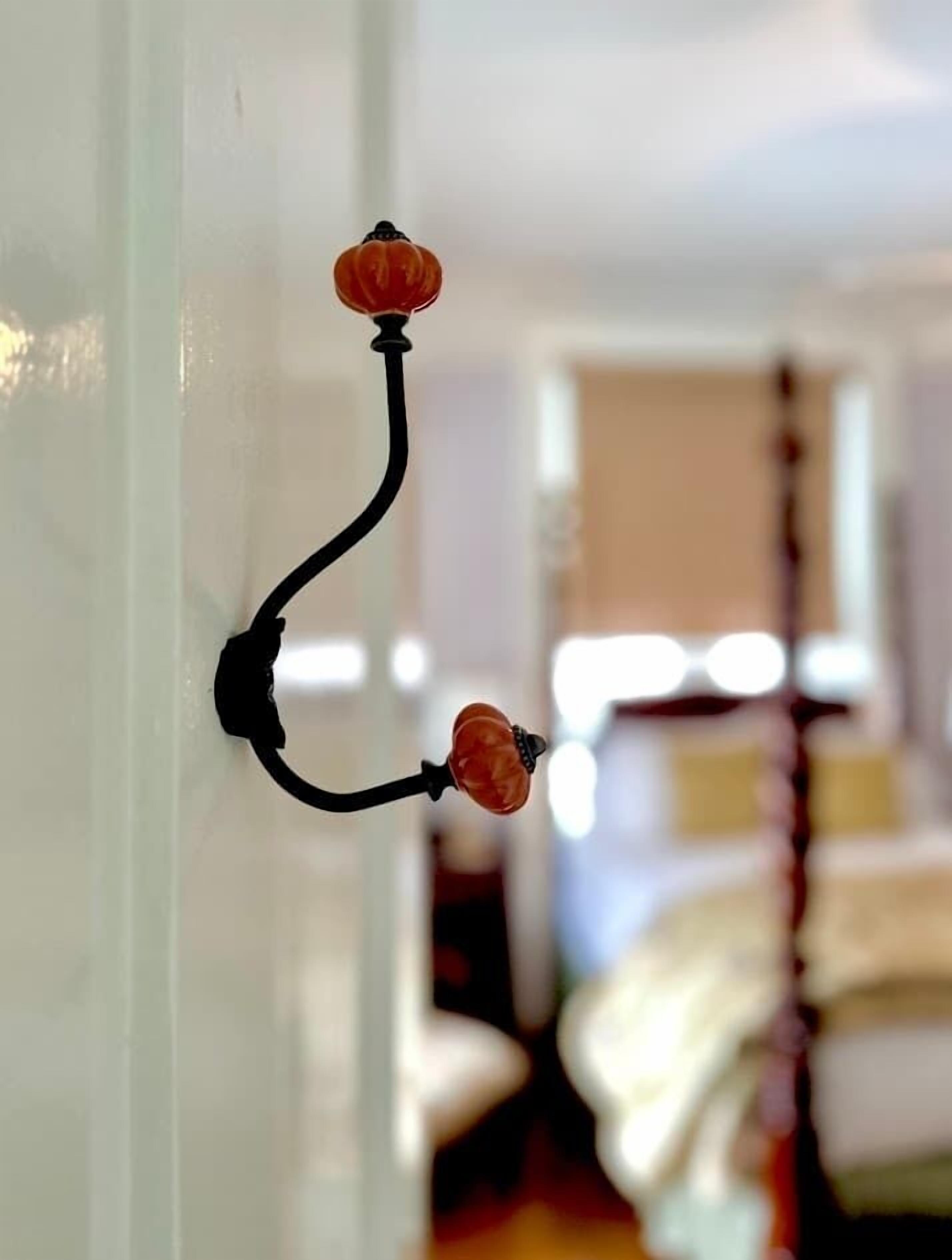 A wall-mounted hook with two orange decorative elements.