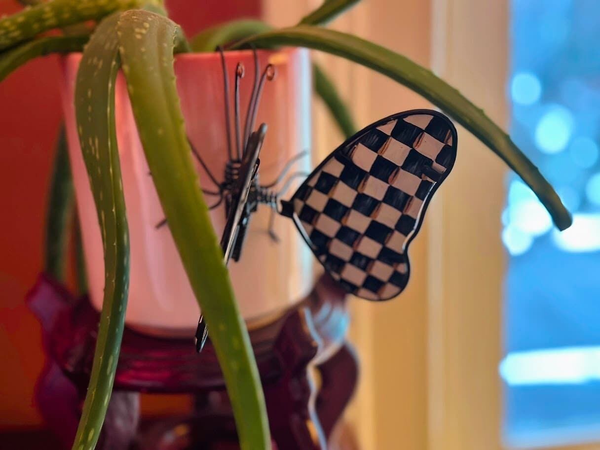 Una mariposa decorativa sobre una planta.