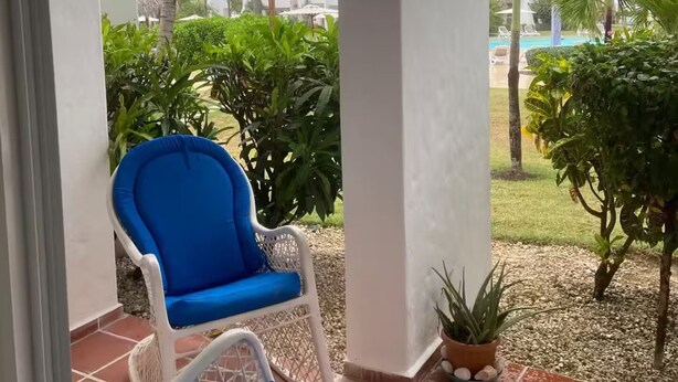 A covered outdoor area with a blue chair and a potted plant. - Beach Apartment in Stanza Mare Punta Cana (Punta Cana)