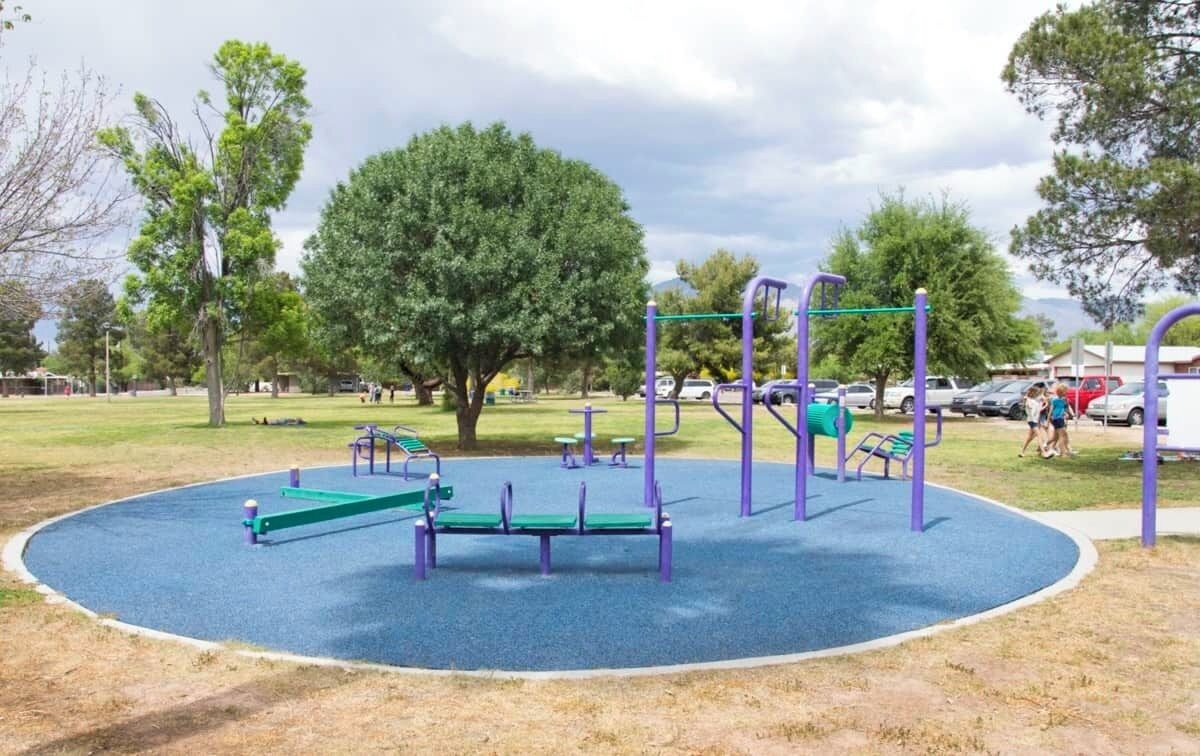 Een speeltuin met diverse speeltoestellen, zoals schommels, een glijbaan en klimconstructies.