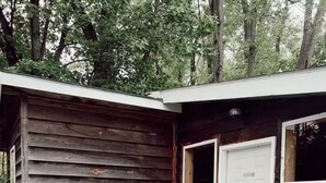 A wooden cabin with a barbecue grill, a welcome mat, and a small porch area. - Charming 2-bedroom cabin with AC in West Chazy (West Chazy)