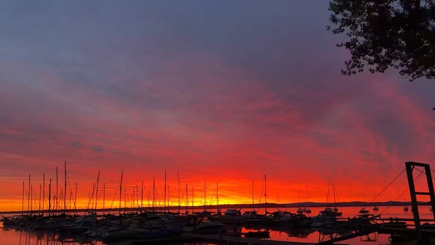 A marina at sunset with boats docked and a bridge in the background. - Charming 2-bedroom cabin with AC in West Chazy (West Chazy)