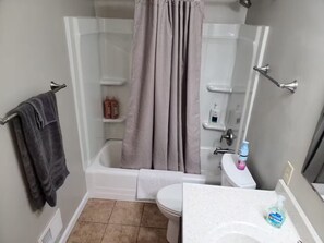 Ein Badezimmer mit Dusche, Toilette und Waschbecken.