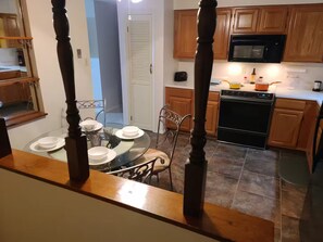 Una cocina con armarios de madera, microondas y estufa.
