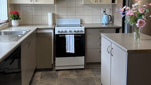 Una cocina moderna con horno empotrado, refrigerador de acero inoxidable y estufa a gas.