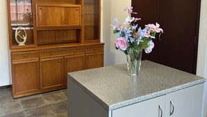 Una cocina con encimera de granito, armarios de madera y un guardarropa de madera oscura.