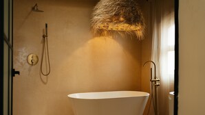 A modern bathroom with a freestanding bathtub, a showerhead, and a towel rack. - Oasis with Swimming Pool in the Heart of Oaxaca (Oax.)