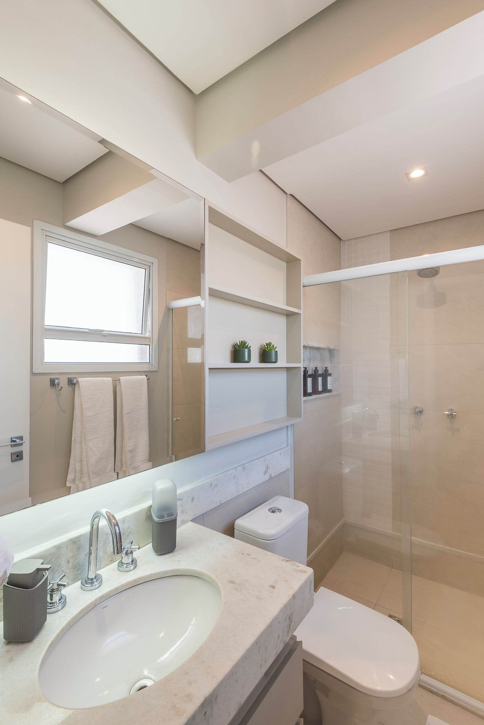 A modern bathroom with a large sink, mirror, and glass-enclosed shower.