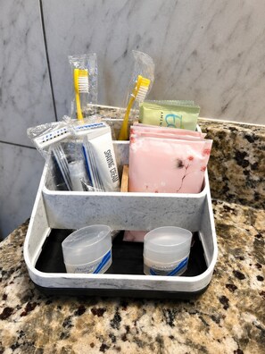 A bathroom sink organizer with toothbrushes, shaving cream, and a soap dispenser.